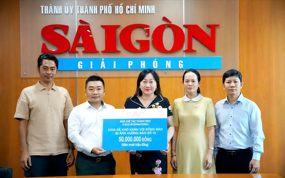 Báo Sài Gòn Giải Phóng tiếp nhận bảng trao 50 triệu đồng chia sẻ khó khăn với đồng bào bị ảnh hưởng bão số 10 từ Nhà chế tác Thắng Eric. Ảnh: VIỆT NGA