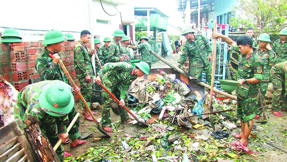 兵士たちがティナイラグーン(ザライ省)沿いの住宅街でゴミを収集している H1w.jpg