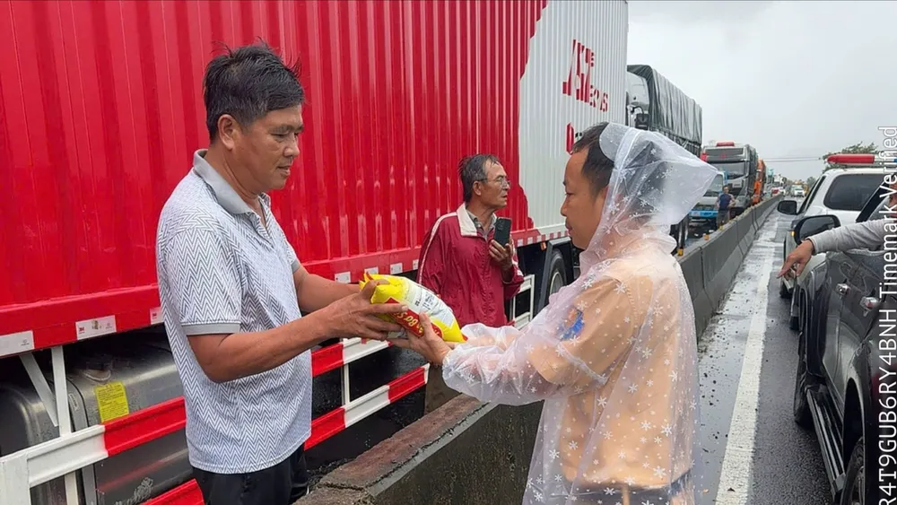 Lực lượng CSGT tiếp tế thực phẩm cho các tài xế có phương tiện bị kẹt trên quốc lộ 1A