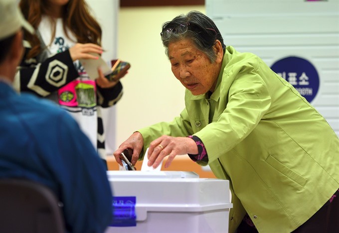 A South Korean elderly woman casts her vote in the presidential election at a polling station in Seoul on Tuesday. — AFP/VNA