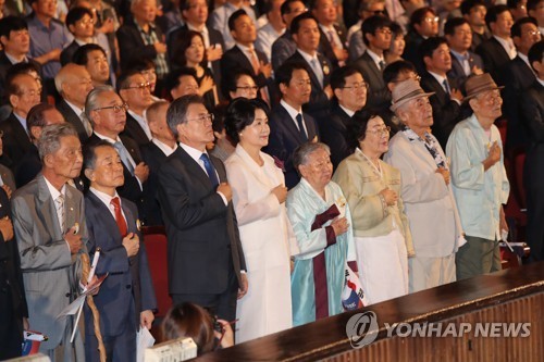 President Moon Jae-in (front row, third from L) salutes the national flag in a ceremony marking the country's 1945 liberation from the Japanese colonial rule in a ceremony held in Seoul on Aug. 15, 2017. (Yonhap)