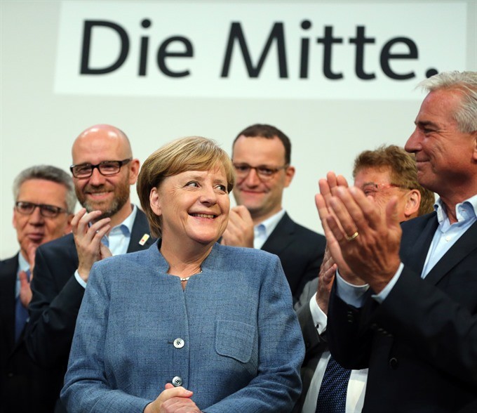 German sitting Chancellor Angela Merkel (L, Front) is applauded after the preliminary exit poll at the Christian Democratic Union (CDU) party’s headquarters in Berlin, Germany, on Sunday