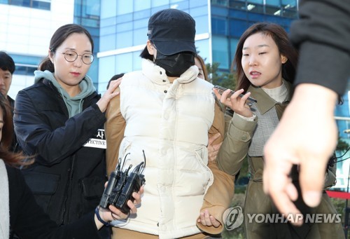 A 14-year-old girl (center) enters a court in Seoul on Oct. 30. 2017, to attend an arraignment after an arrest warrant was requested for her over the death of her middle school friend at the hands of her father. (Yonhap)