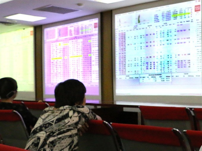 Investors follow transactions at Saigon Securities Inc (SSI) in Hà Nội. — VNS Photo Đoàn Tùng