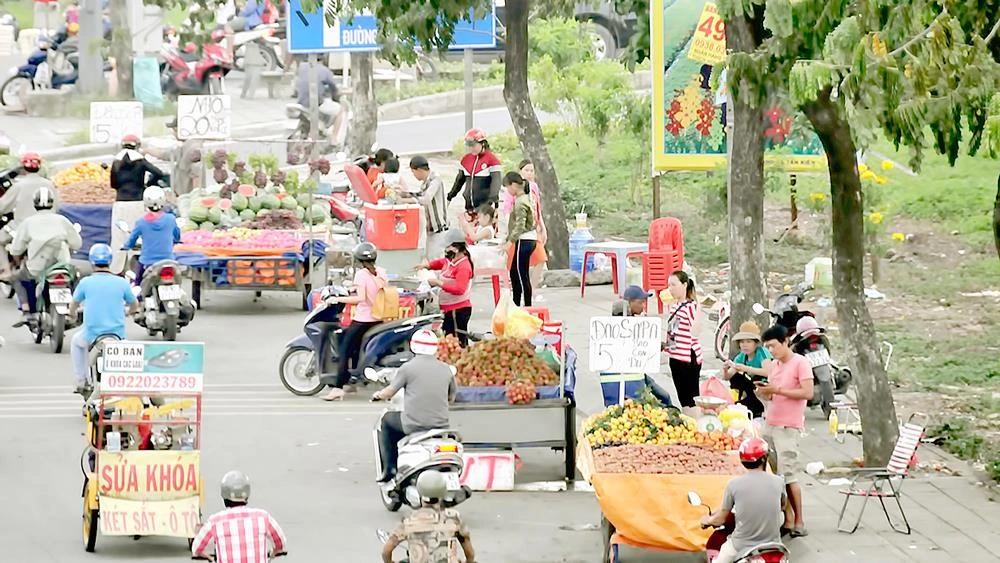 Xe hàng rong buôn bán lấn chiếm lòng đường quốc lộ 1A đoạn qua huyện Bình Chánh. Ảnh: THÀNH TRÍ