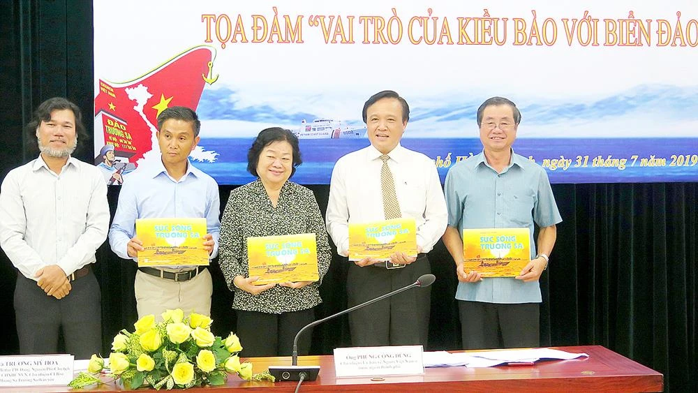 Ông Hoàng Chí Hùng (bìa trái), Chủ nhiệm CLB Ảnh báo chí Hội Nhà báo TPHCM, tặng các đại biểu sách ảnh về biển đảo