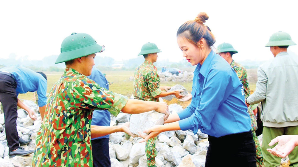 Đoàn viên thanh niên huyện Mỹ Đức hỗ trợ lực lượng quân đội xây dựng tường rào sân bay Miếu Môn. Ảnh: ĐỖ TRUNG