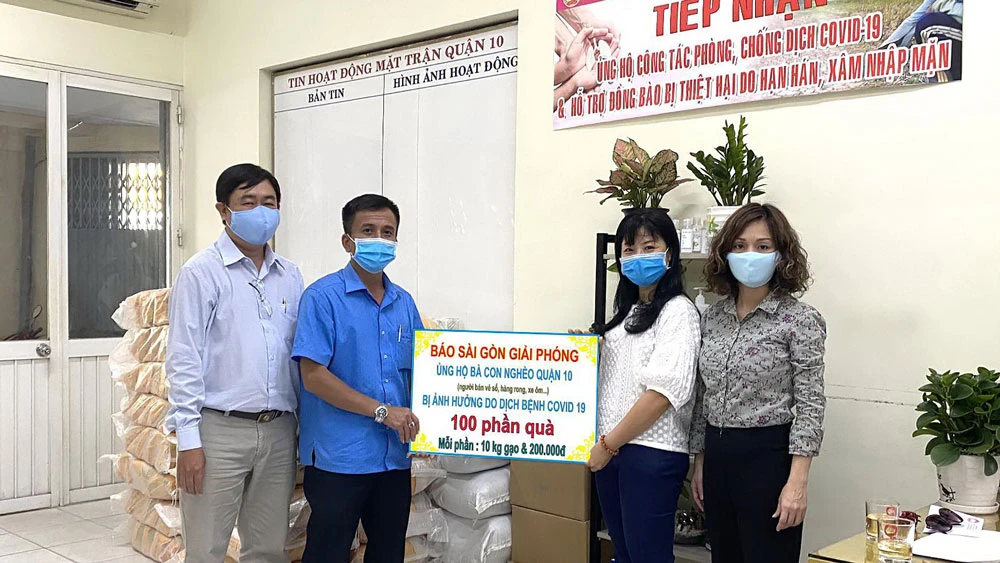 Đại diện Báo SGGP chuyển Ủy ban MTTQ quận 10 số tiền và quà giúp người bán vé số. Ảnh: NGỌC NGÂN