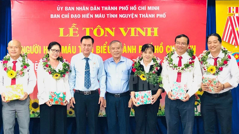 Phó Trưởng ban Dân vận Thành ủy TP Nguyễn Văn Lưu và Chủ tịch Hội Chữ thập đỏ TP Trần Trường Sơn tặng hoa chúc mừng các cá nhân điển hình hiến máu tình nguyện. Ảnh: Thanhuytphcm.vn