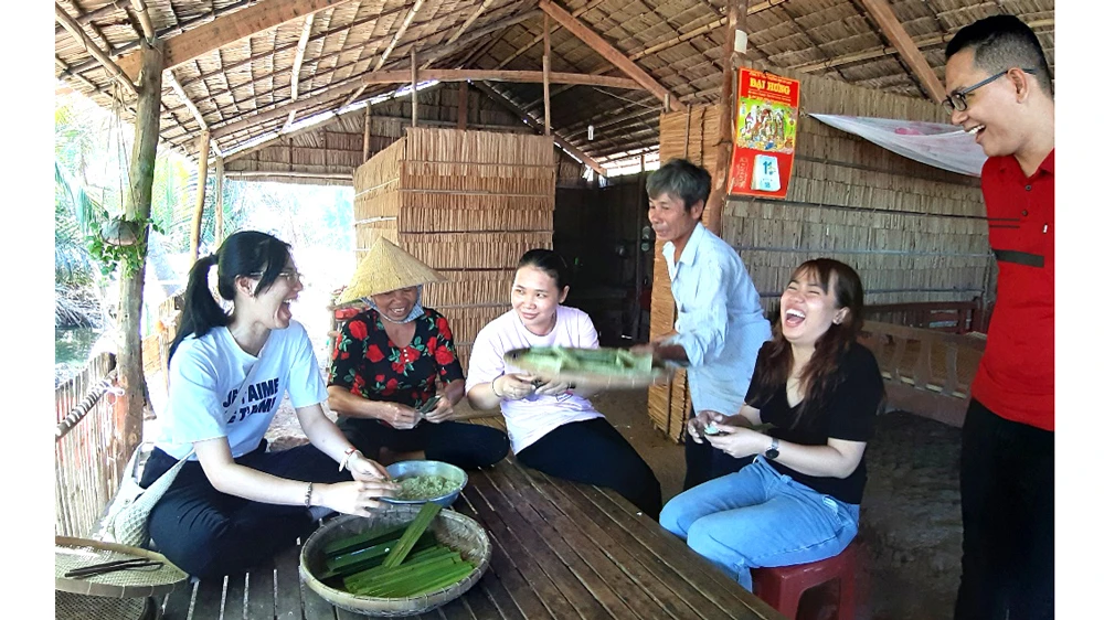 Du khách thích thú khi được tự tay làm bánh ở khu du lịch Cồn Chim (Trà Vinh)