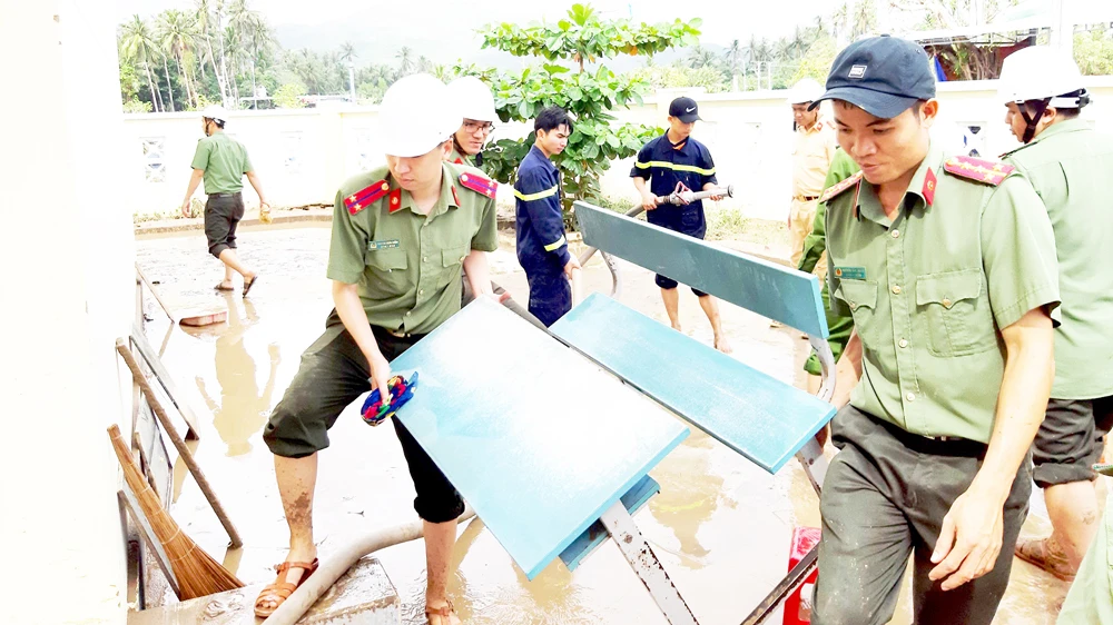 Công an tỉnh Phú Yên giúp người dân thị xã Sông Cầu khắc phục hậu quả bão số 12. Ảnh: XUÂN HUYÊN