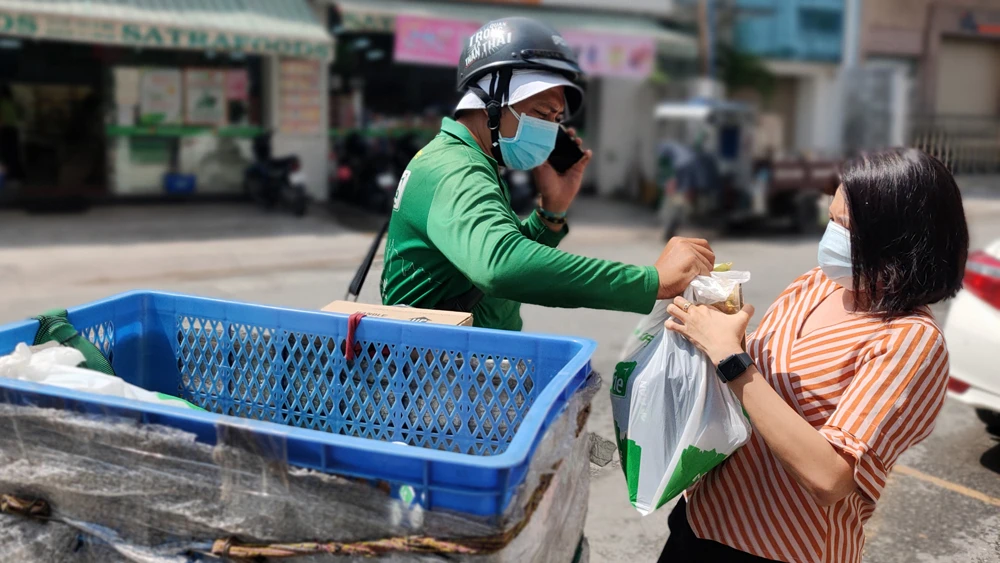 Những ngày này, lượng tài xế giao hàng trực tuyến tăng so với ngày thường, kèm theo đó là những lo lắng về phòng dịch. Ảnh: DŨNG PHƯƠNG