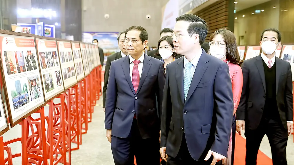 Đồng chí Võ Văn Thưởng và các đại biểu xem triển lãm ảnh “60 năm một chặng đường vẻ vang công tác đảng ngoài nước”. Ảnh: QUANG PHÚC