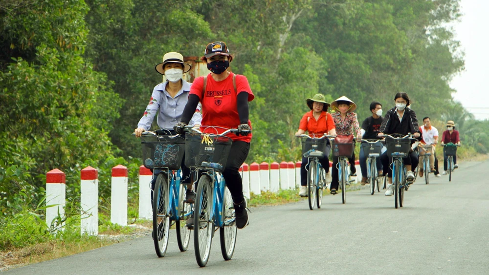 Du khách trải nghiệm đạp xe, ngắm cảnh tại xã Lê Minh Xuân, huyện Bình Chánh, do Công ty cổ phần Dịch vụ Lữ hành Chim Cánh Cụt tổ chức