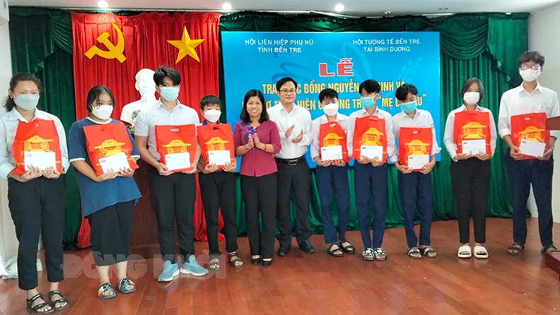 Trao tiền hỗ trợ cho các em học sinh mồ côi cha hoặc mẹ do ảnh hưởng dịch Covid-19. Ảnh: BDK.VN