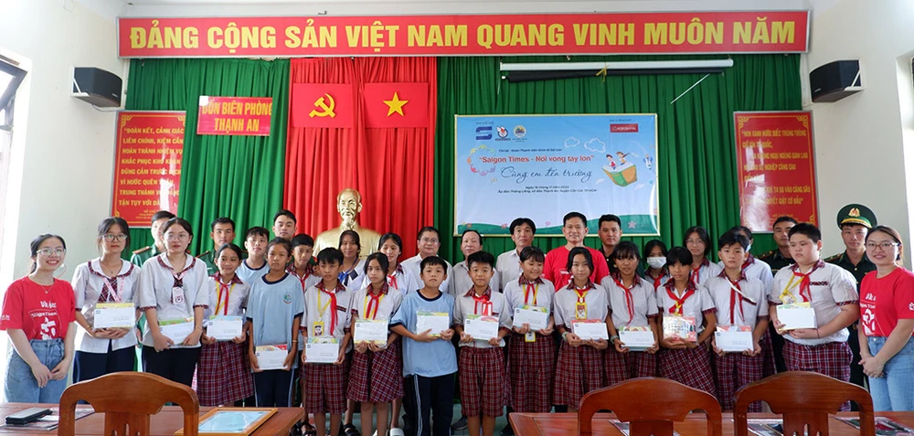 Đại diện các đơn vị tài trợ, Đồn biên phòng Thạnh An cùng các em học sinh của ấp Thiềng Liềng chụp ảnh lưu niệm tại buổi lễ trao học bổng