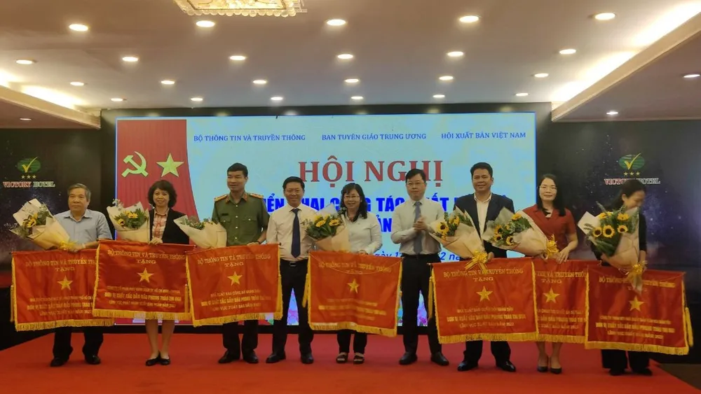 Ông Nguyễn Thanh Lâm, Thứ trưởng Bộ TT-TT (thứ 4, từ phải sang) và ông Trần Thanh Lâm, Phó trưởng Ban Tuyên giáo Trung ương (thứ 6, từ phải qua) tặng cờ thi đua của Bộ TT-TT cho 11 đơn vị xuất bản, in và phát hành có thành tích cao trong năm 2022