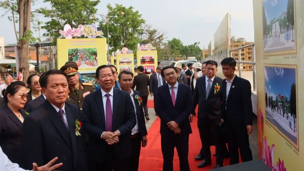 Đồng chí Phan Văn Mãi và Bí thư, Tỉnh trưởng Savannakhet Bounchom Ubonpaseuth xem triển lãm ảnh