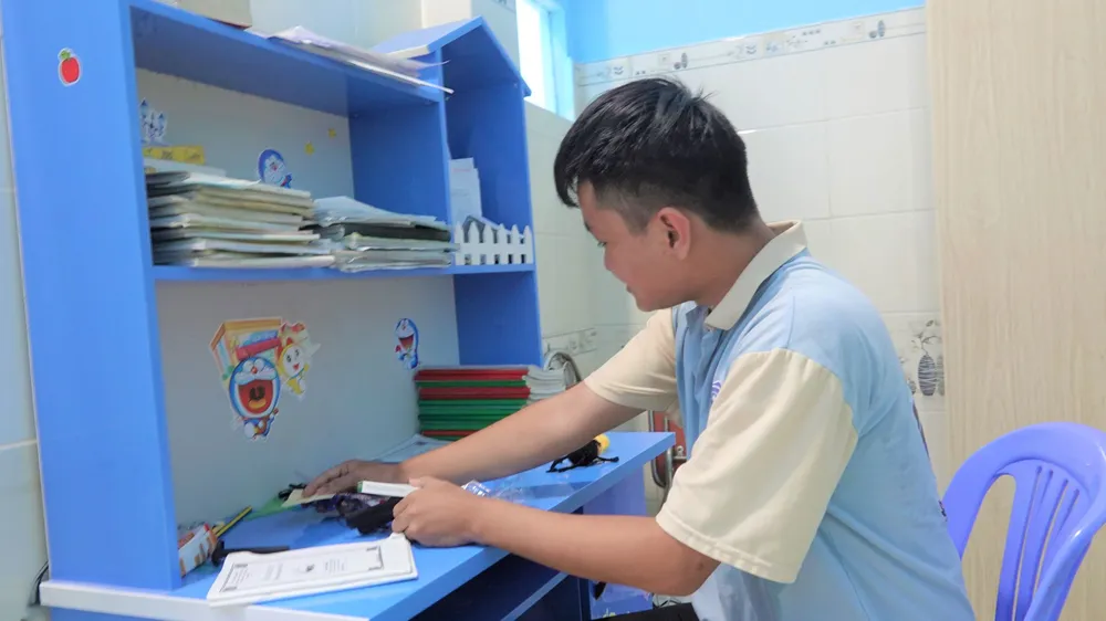 Em Phan Văn Trường đang sắp xếp tại góc học tập của mình. Ảnh: XUÂN QUỲNH Em Phan Văn Trường đang sắp xếp tại góc học tập của mình. Ảnh: XUÂN QUỲNH