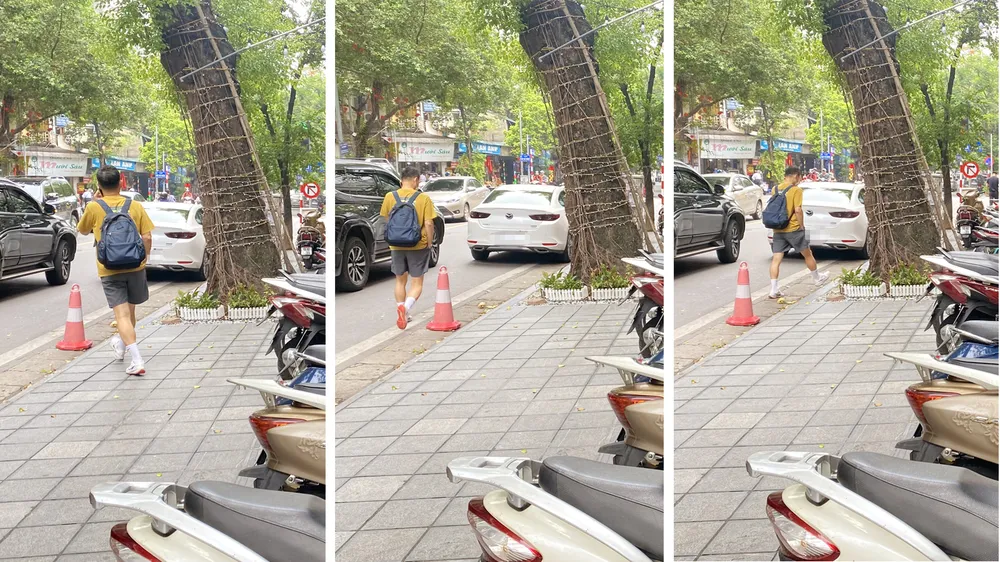 Một người đi bộ trên vỉa hè phố Lê Văn Hưu phải vòng xuống lòng đường để tránh gốc cây