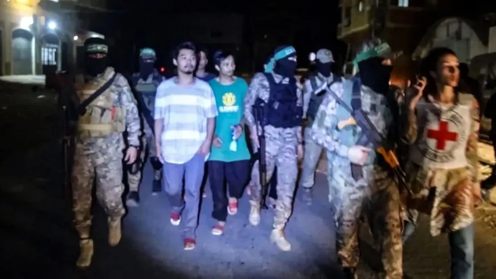 Các tay súng Hamas trao trả con tin Thái Lan cho Ủy ban Chữ thập Đỏ Quốc tế tại Dải Gaza, ngày 26-11. Ảnh: TTXVN