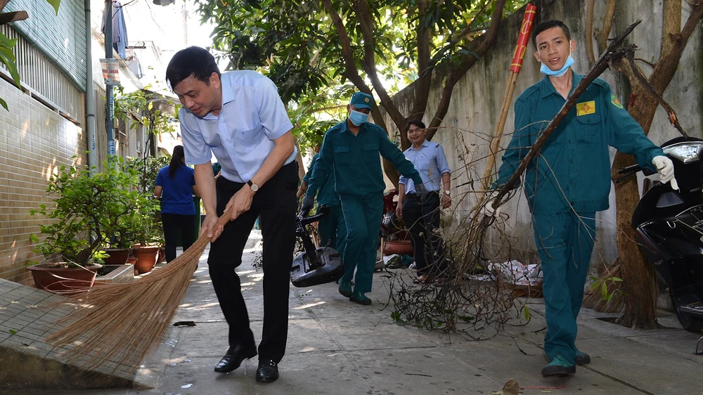 Lãnh đạo quận 7 tham gia dọn vệ sinh cùng người dân. Ảnh: VIỆT DŨNG