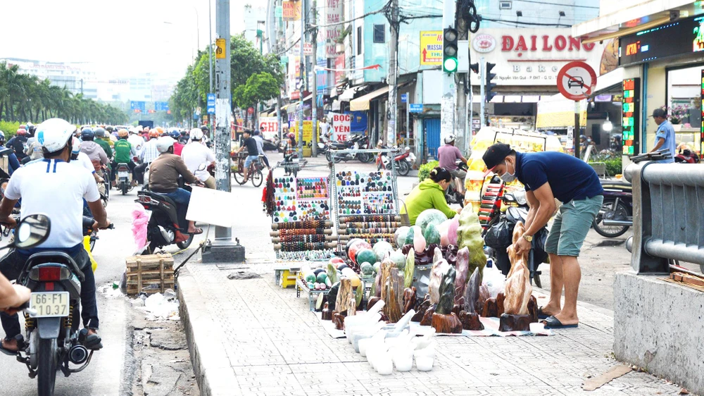 Tại dốc cầu Chợ Cầu, hàng hóa được bày bán tràn lan, gây mất an toàn giao thông