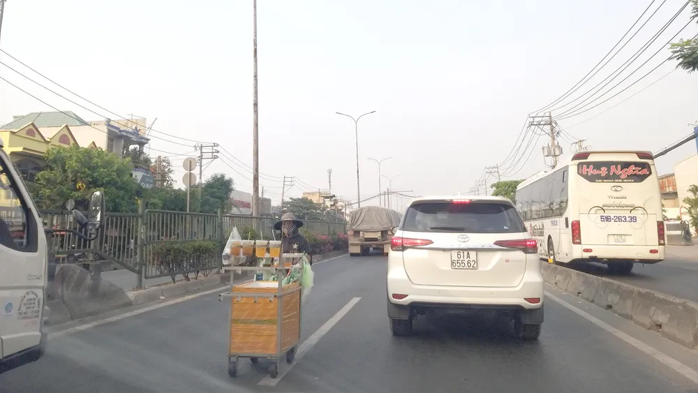 Hàng rong bất chấp hiểm nguy lấn chiếm lòng đường quốc lộ 1A