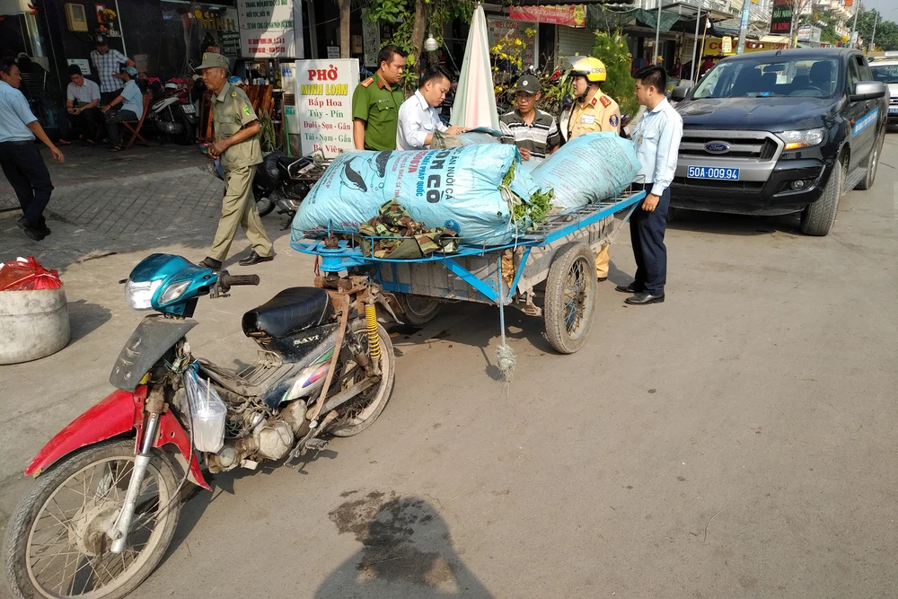 Lực lượng chức năng quận 8 xử lý một xe lôi đậu sai quy định, mua bán hàng hóa trên đường Quản Trọng Linh