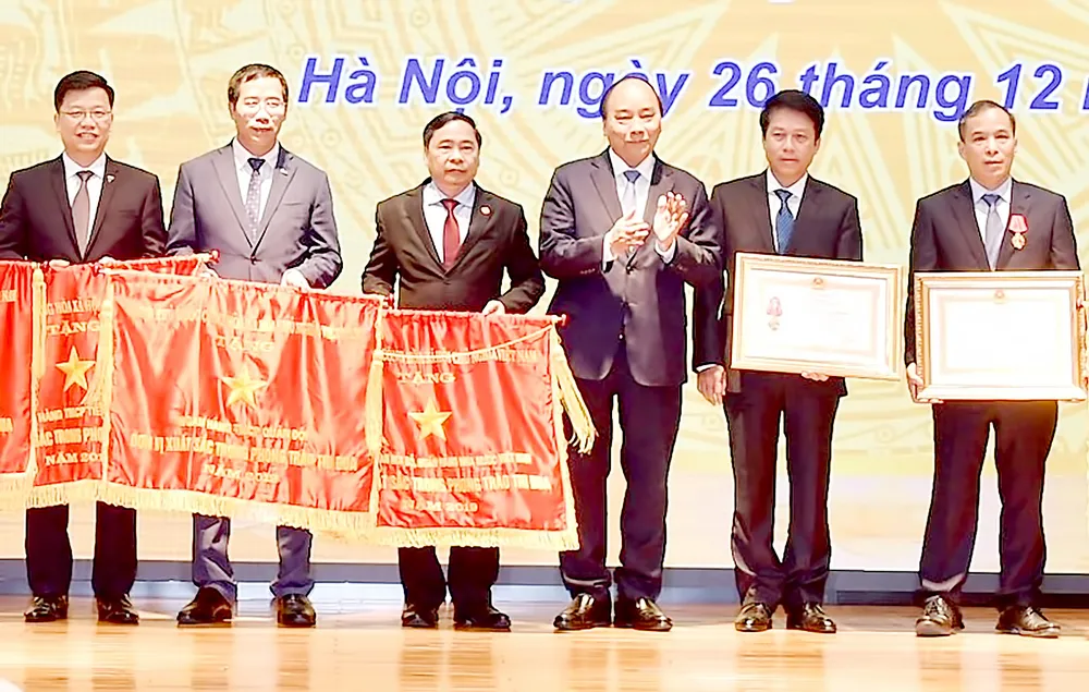 Thủ tướng Nguyễn Xuân Phúc trao Huân chương Lao động và Cờ thi đua cho các tập thể, cá nhân xuất sắc của Ngân hàng Nhà nước. Ảnh: VIẾT CHUNG