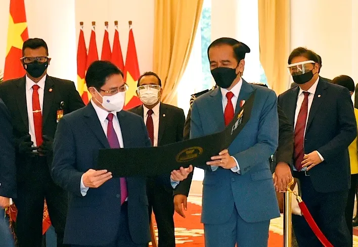 Tổng thống Indonesia Joko Widodo thân tặng Thủ tướng Phạm Minh Chính tấm hình kỷ niệm cuộc gặp đầu tiên trên cương vị Thủ tướng. Ảnh: VGP