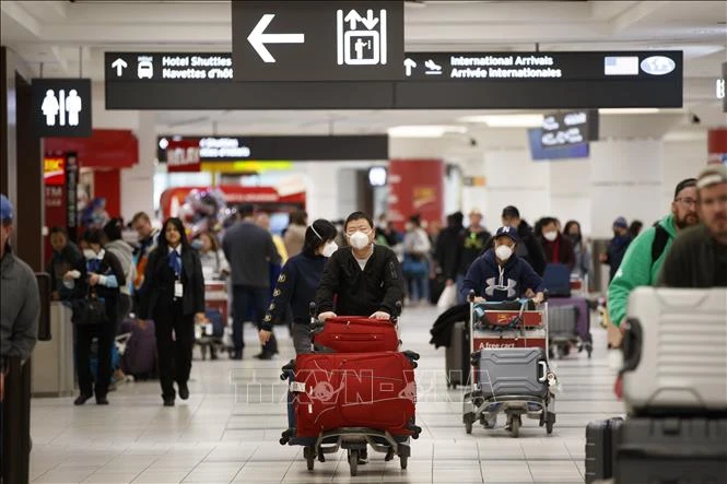 Hành khách tại sân bay Pearson ở Toronto, Canada. Ảnh: AFP/TTXVN