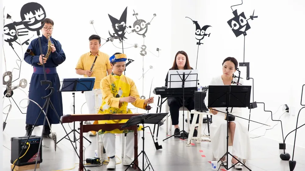 Dương Bảo Khánh (giữa) biểu diễn đàn bầu cùng ban nhạc tại Hàn Quốc