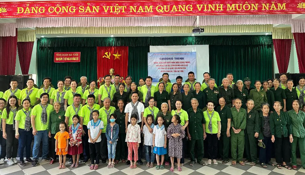 Các thành viên trong đoàn hành trình về nguồn &quot;Tự hào Tổ quốc tôi&quot; chụp ảnh lưu niệm với các cựu Thanh niên xung phong và học sinh được tặng quà ở huyện Can Lộc, tỉnh Hà Tĩnh.Ảnh: MAI TRỌNG NGHI