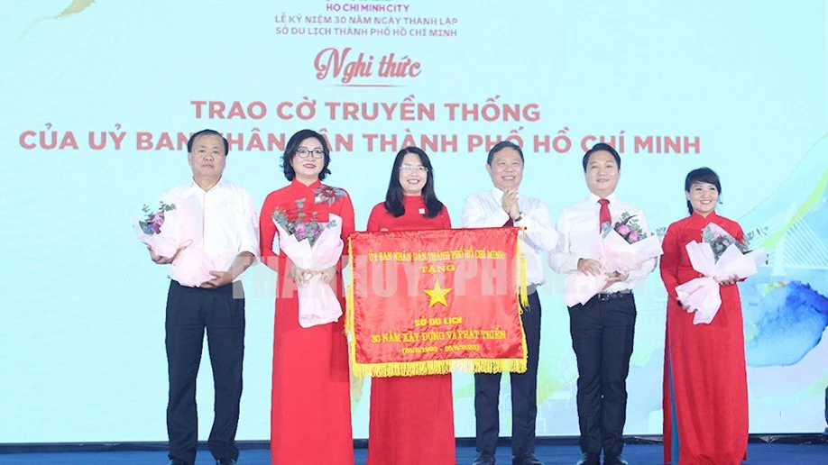 Phó Chủ tịch UBND TPHCM Dương Anh Đức trao cờ truyền thống của UBND TPHCM đến tập thể Sở Du lịch. Ảnh: Thanhuy.vn