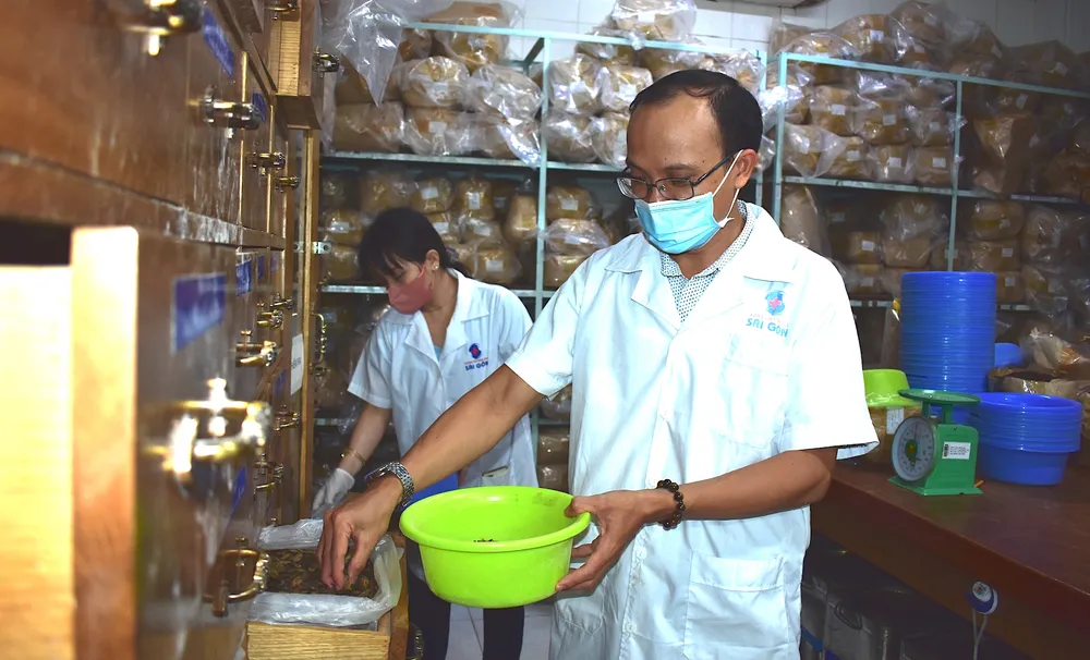 Nhân viên Viện Y dược học dân tộc TPHCM bốc thuốc theo toa cho người bệnh