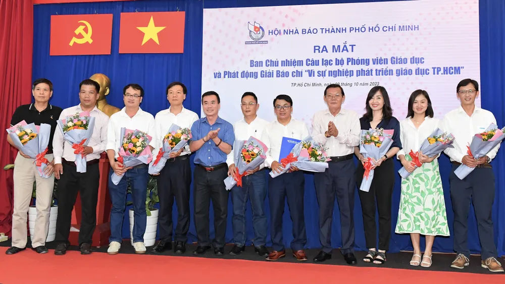 Chủ tịch Hội Nhà báo TPHCM Nguyễn Tấn Phong và Phó Chủ tịch Thường trực Hội Nhà báo TPHCM Dương Vũ Thông tặng hoa chúc mừng Ban chủ nhiệm Câu lạc bộ phóng viên giáo dục TPHCM. Ảnh: VIỆT DŨNG