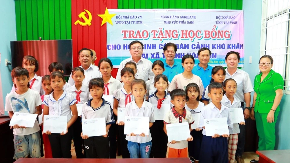 Lãnh đạo Hội Nhà báo tỉnh Trà Vinh, Agribank CN tỉnh Trà Vinh tặng học bổng cho học sinh xã Thạnh Hòa Sơn, huyện Cầu Ngang. Ảnh: CTV