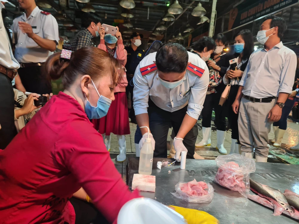 Lực lượng chức năng lấy mẫu kiểm nghiệm an toàn thực phẩm tại chợ đầu mối Hóc Môn V2a.jpg