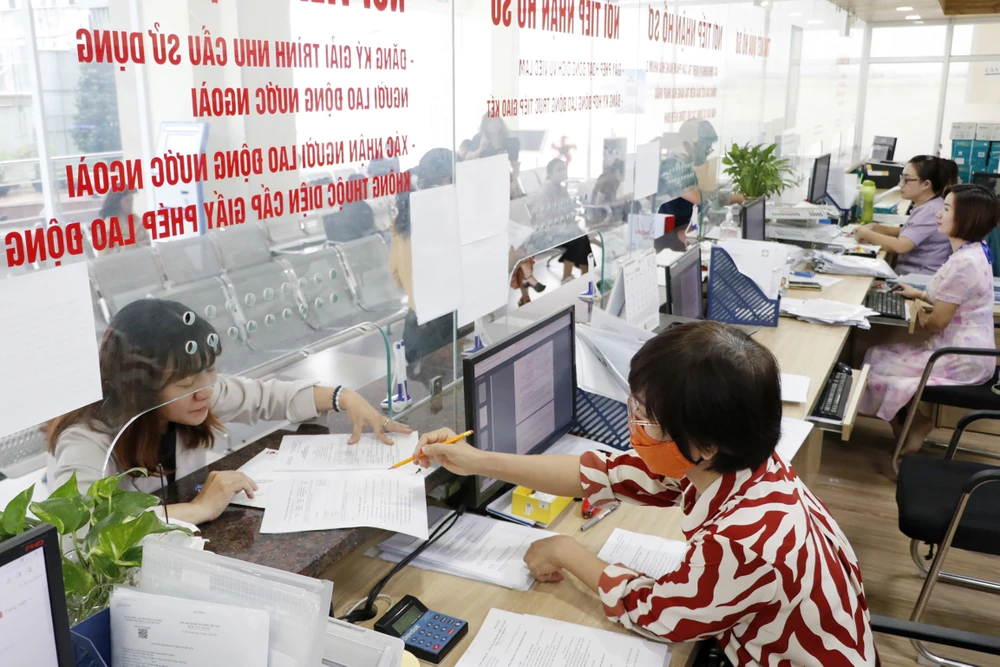 Công chức Sở LĐTBXH TPHCM hướng dẫn người dân làm thủ tục hành chính. Ảnh NGÔ BÌNH cong-chuc-so-ldtbxh-tphcm-huong-dan-nguoi-dan-lam-thu-tuc-hanh-chinh-anh-ngo-binh-3913.jpg