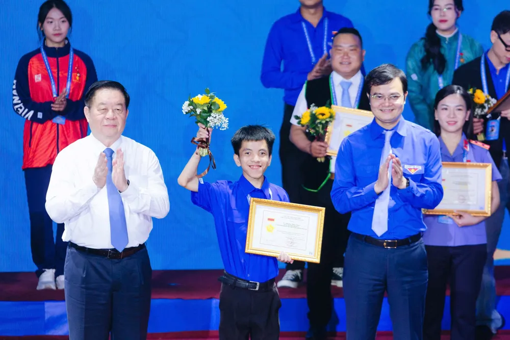 Đồng chí Nguyễn Trọng Nghĩa, Trưởng Ban Tuyên giáo và Dân vận Trung ương và đồng chí Bùi Quang Huy, Bí thư thứ nhất Trung ương Đoàn TNCS HCM trao danh hiệu Thanh niên tiên tiến làm theo lời Bác toàn quốc lần thứ 8, năm 2025 cho Chương Đình Phúc. Ảnh: NVCC H4c.jpg