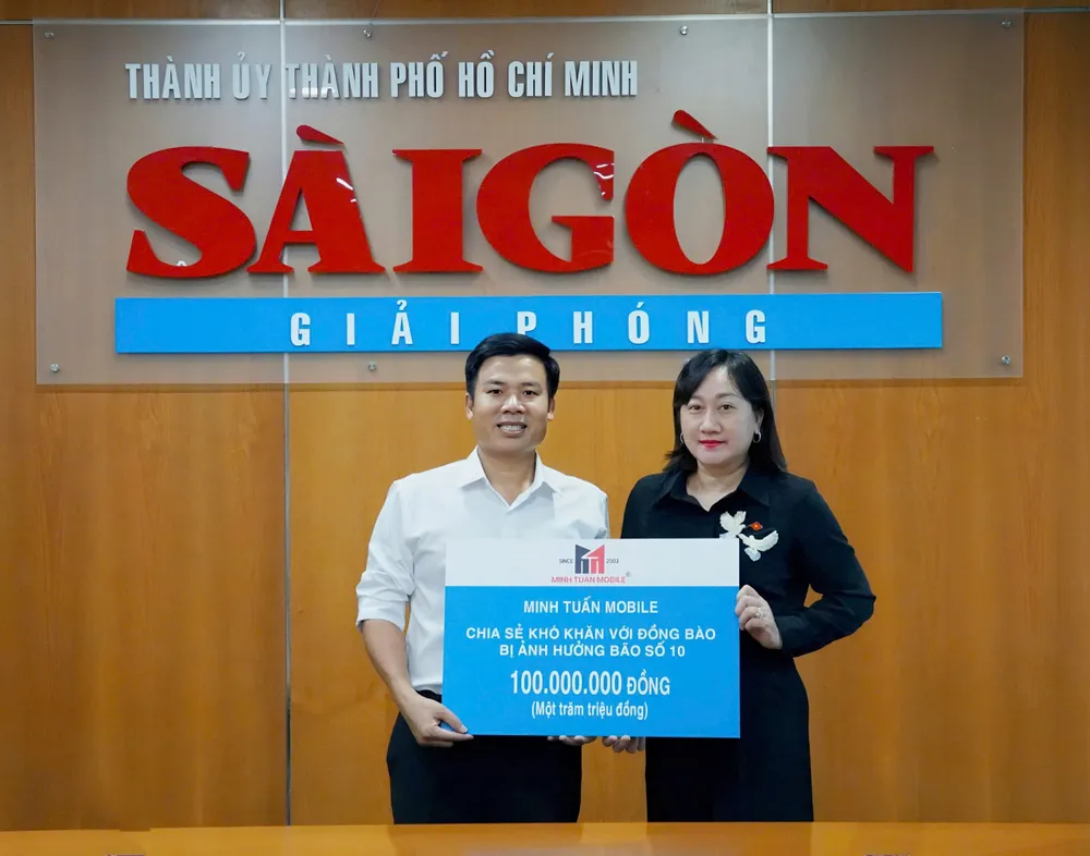 Phó Tổng Biên tập Báo SGGP Bùi Thị Hồng Sương tiếp nhận bảng tượng trưng trị giá 100 triệu đồng từ ông Nguyễn Minh Tuấn, Giám đốc hệ thống Minh Tuấn Mobile. Ảnh: VIỆT NGA z7070581853888-970cbdd3bcf036b1d0f131a7189c4cac-9421-8122.jpg