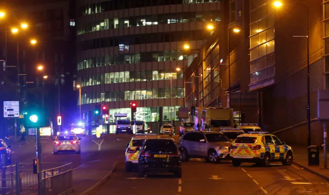 Xe cảnh sát đậu gần Manchester Arena, nơi xảy ra vụ nổ. No lon o nha thi dau Manchester, 22 nguoi chet hinh anh 3