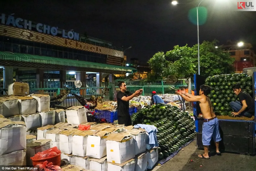 Anh Biên (ngoài cùng bên trái) khẩn trương xếp dưa hấu vừa chuyển từ dưới Long An lên. Anh Biên (ngoài cùng bên trái) khẩn trương xếp dưa hấu vừa chuyển từ dưới Long An lên.