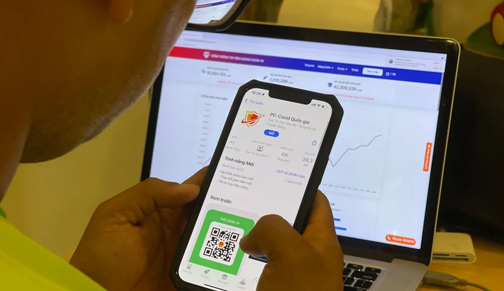 Người dân tìm hiểu ứng dụng PC-Covid. Ảnh: HOÀNG HÙNG
