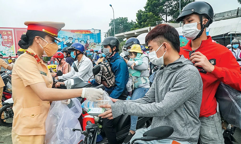 Công an Đồng Nai phát thức ăn, nước uống cho người lao động trên đường về quê.