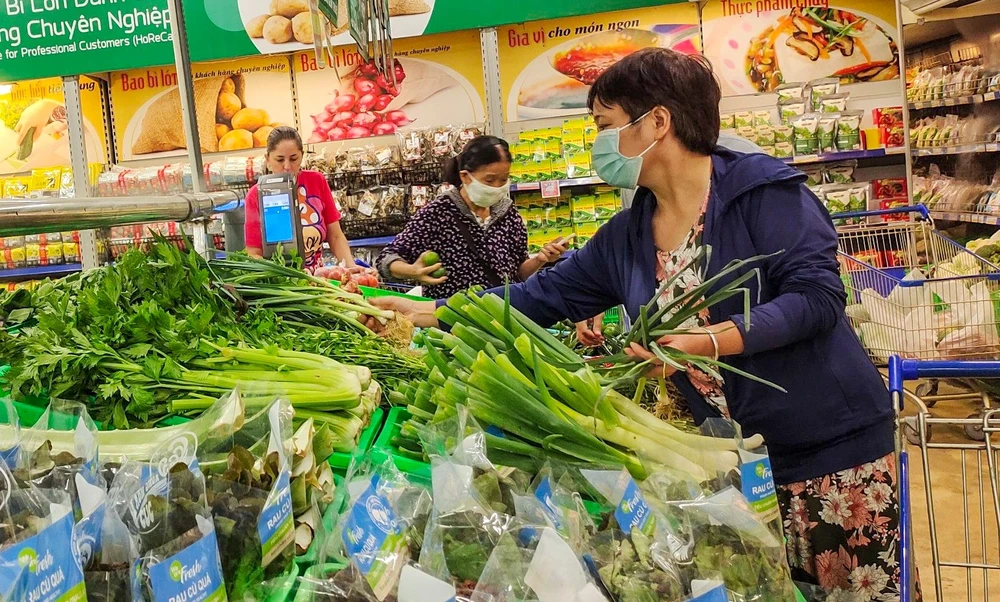 Người tiêu dùng chọn rau tại siêu thị.