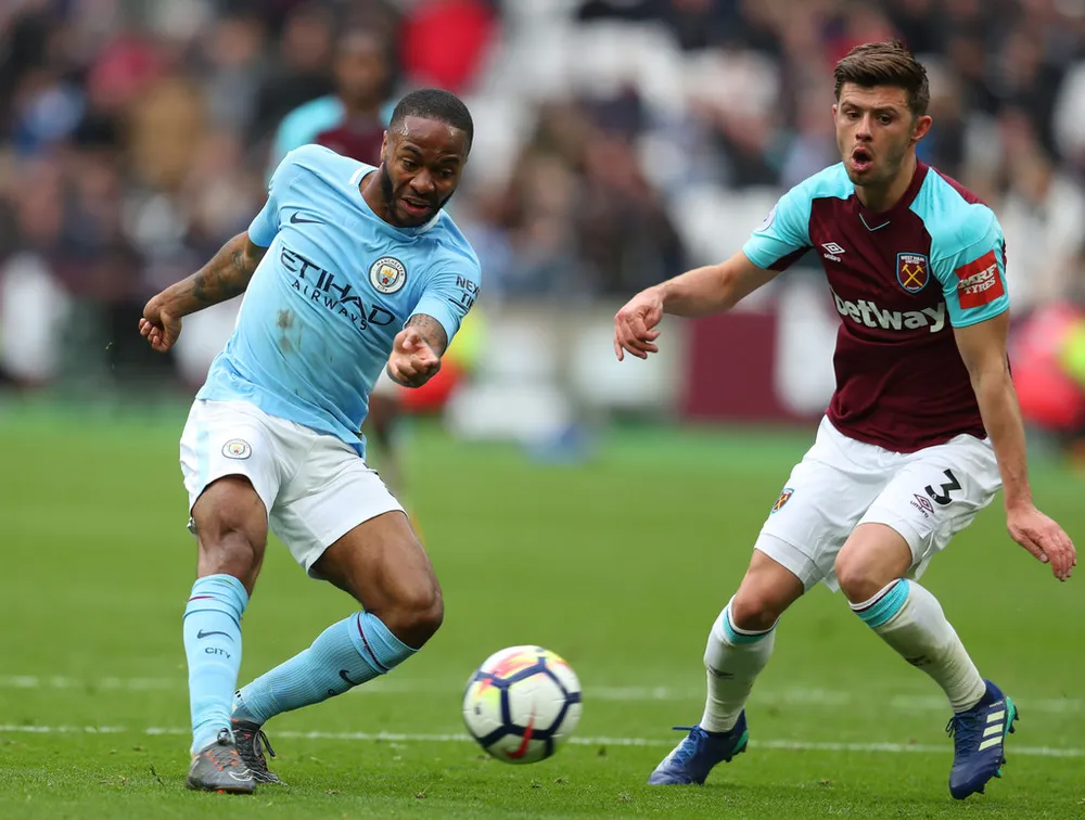 Raheem Sterling (trái, Manchester City) đi bóng qua Aaron Cresswell (West Ham)