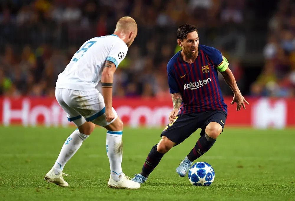 Lionle Messi đi bóng qua hậu vệ PSV.