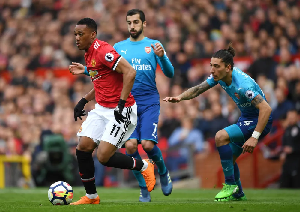 Anthony Martial (Man United, trái) đi bóng qua hàng thủ Arsenal